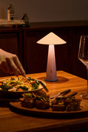 Lamp on a table with food and a glass, warm lighting